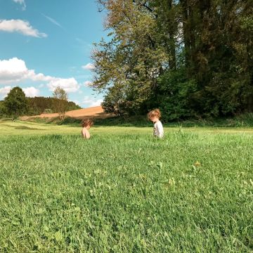 Fotografia de duas crianças em campo aberto