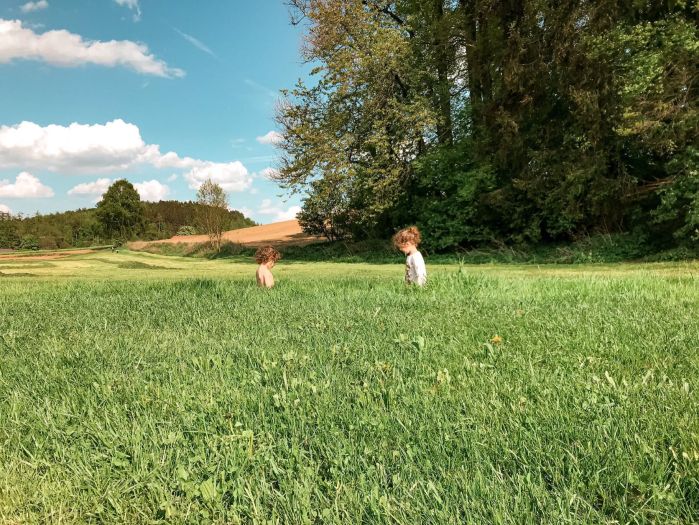 Fotografia de duas crianças em campo aberto